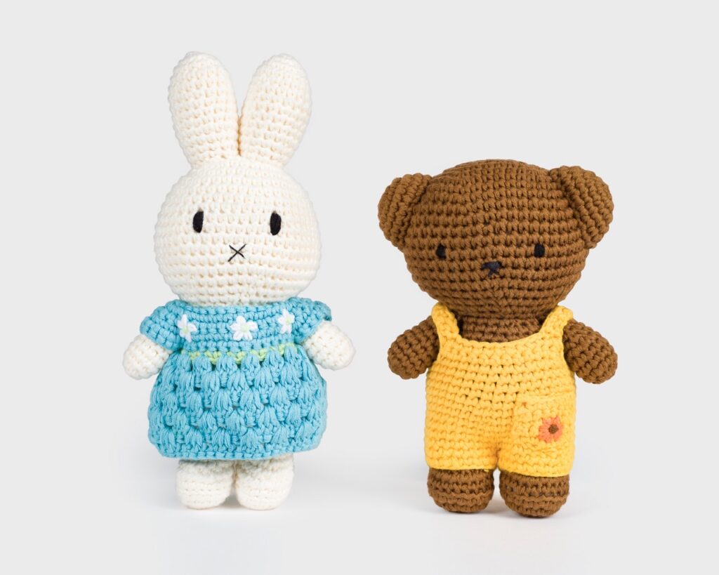 A crochet white bunny beside a crochet brown bear.