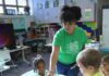 Giving Guide 2025: Sarah Heinz House A woman helps kids at a table color.