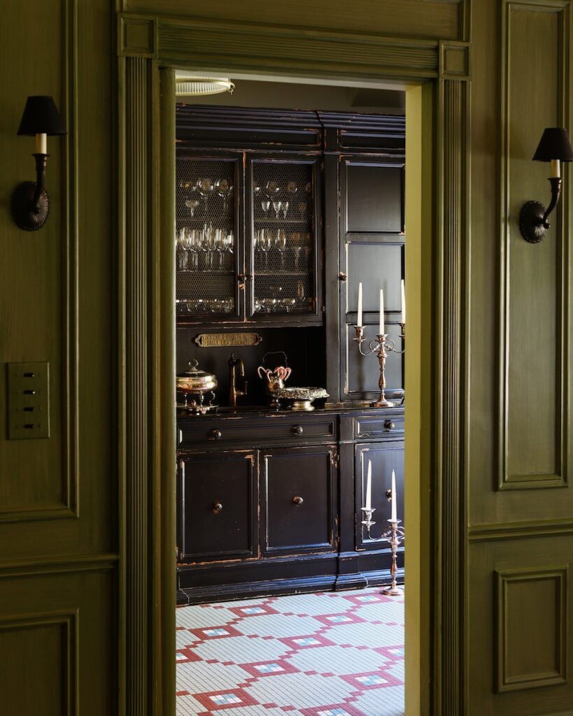 A doorway in Gwen Martin's room with dark green walls and red and white carpeting