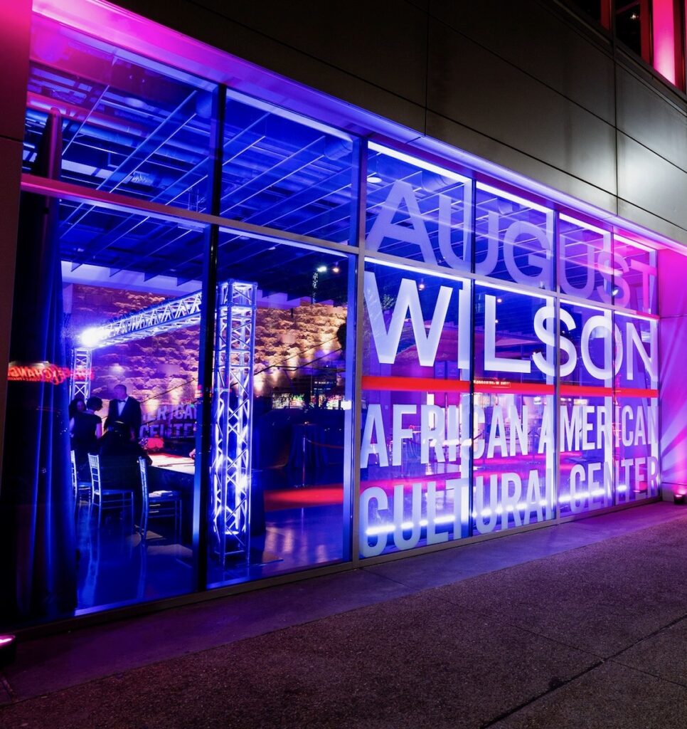 The exterior of the August Wilson Center, lit as purple while a vibrant gala goes on inside of it