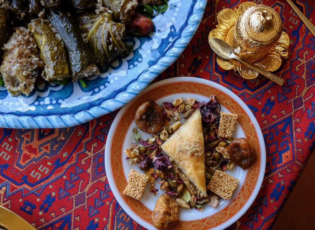 A plate of baklava and dolmas from Khalil's restaurant on a red tablecloth