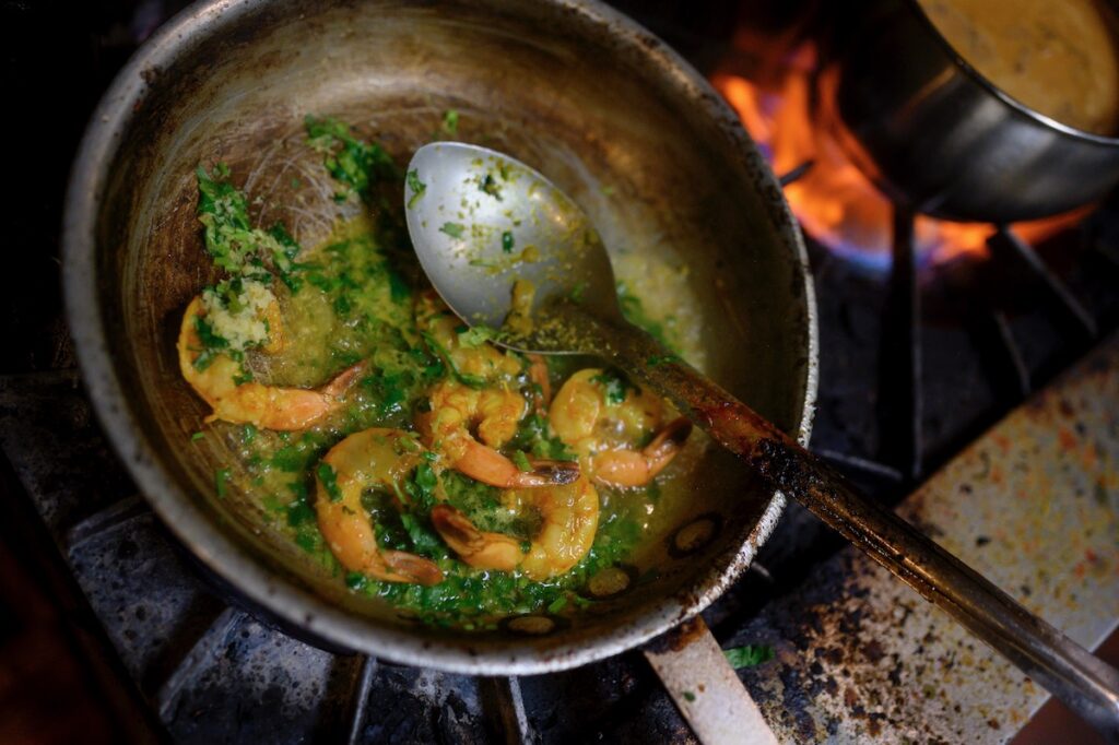 A dish of South Indian seafood fries in a pan on a grill