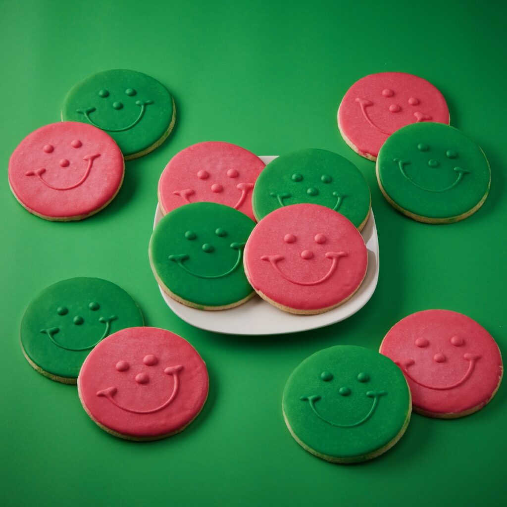 Pink and green Smiley cookies staged on a green background 