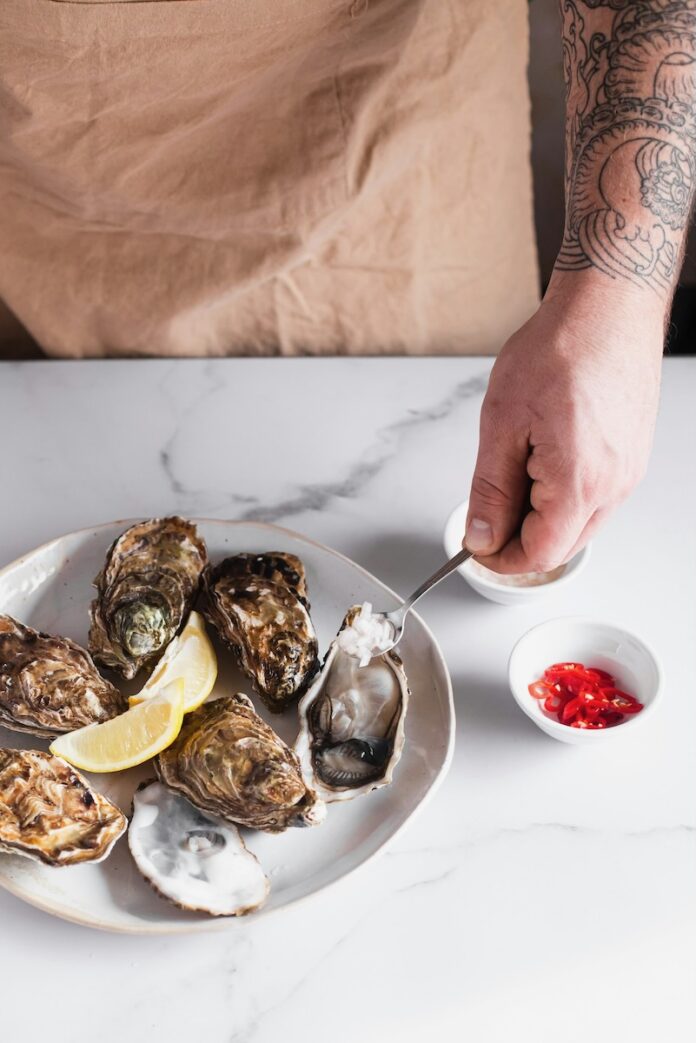 A plate of oysters on a white tablecloth set up for a delectable meal