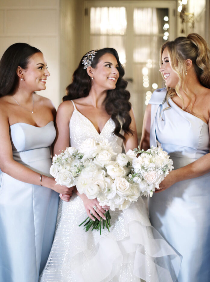The bride and her two bridesmaids posing together, all smiling at the camera, bride and her two bridesmaids posing together, all smiling at the camera.