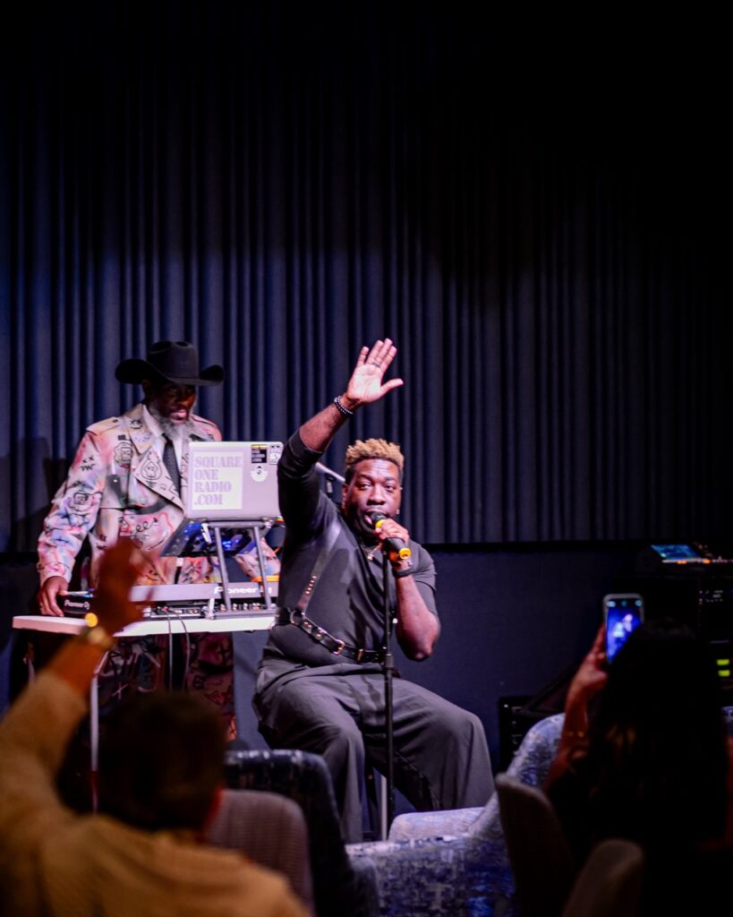 Frzy's Top 5 Must-See Concerts in Pittsburgh 2025 Frzy sings at a Pittsburgh concert on stage with his hand in the air.