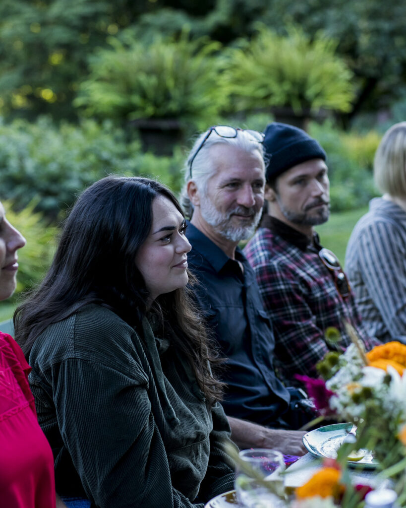 A group of people, presumably the members of the TABLE magazine staff, gathered together in a serene outdoor setting, surrounded by lush greenery.