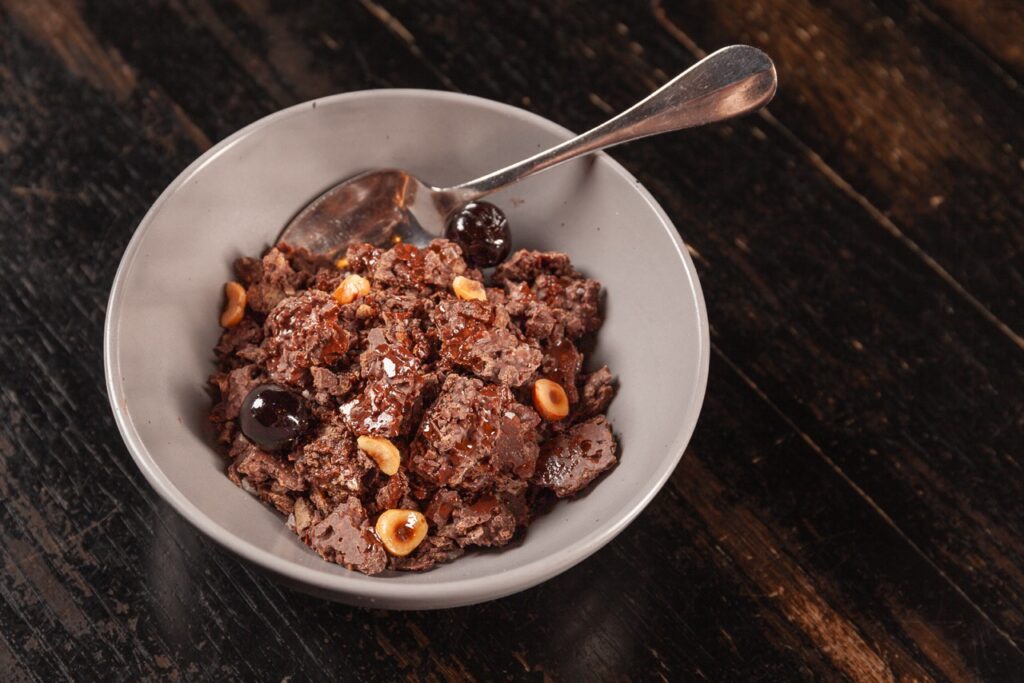 A bowl of chocolate ice cream with toppings.