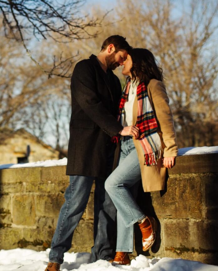 A man and woman embrace in the snow of a Pittsburgh park.