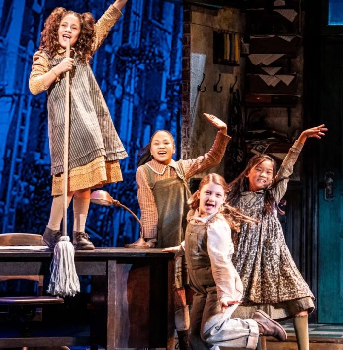 4 young girls sing on a stage in a production of Annie that will take place in March in Pittsburgh.