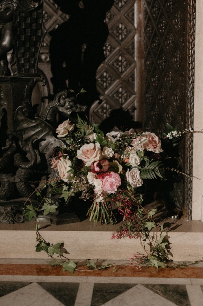 A large bouquet of pink, white, and red flowers adorns the wedding venue's wall.