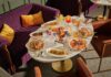Downtown Pittsburgh’s Best Bars and Restaurants for Happy Hour and Beyond A table full of plates beside a purple couch