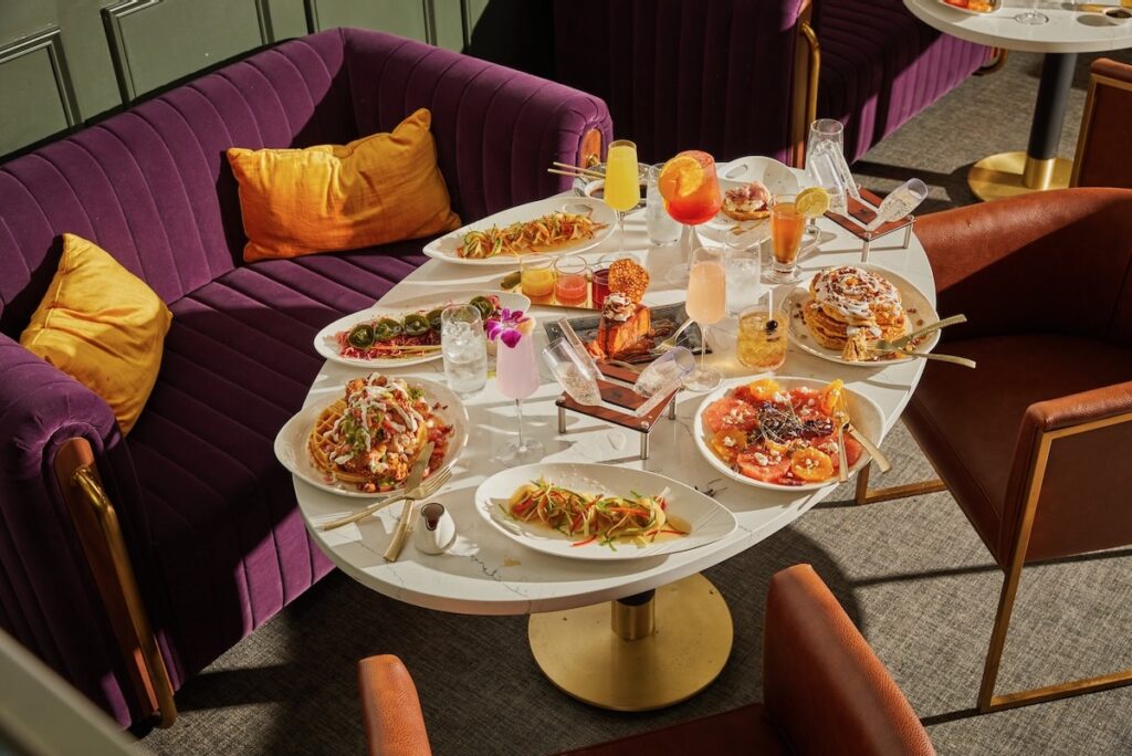 A table full of plates beside a purple couch