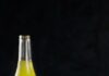 Find Your Perfect Breakfast Burrito in Pittsburgh A breakfast burrito on a black background with a bottle of yellow juice.