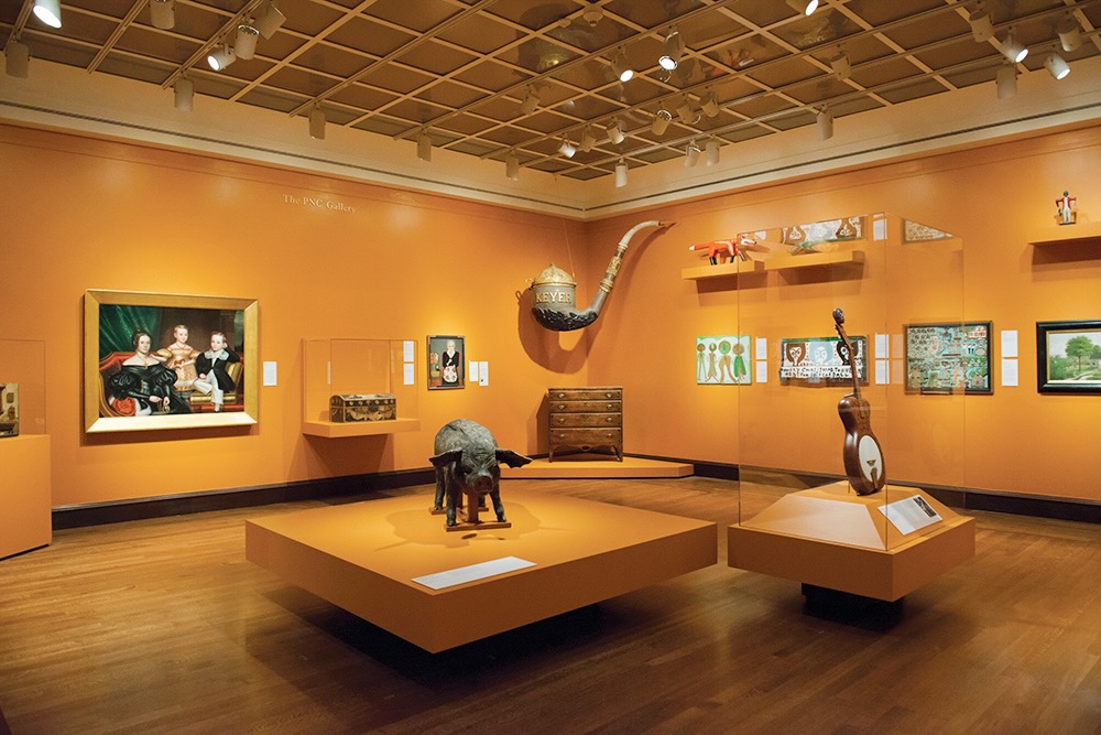 The interior of the Cincinnati Art Museum, artwork on orange walls. 