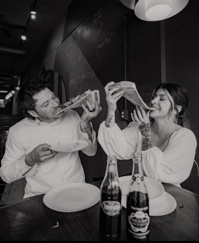 A man and woman bite into late night slices of pizza at Benny Fierro's in Pittsburgh.