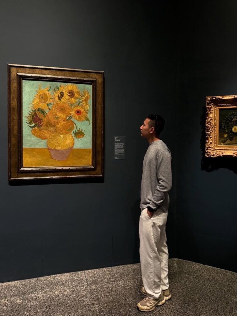 A man looks at a sunflower painting in the Philadelphia Museum of Art