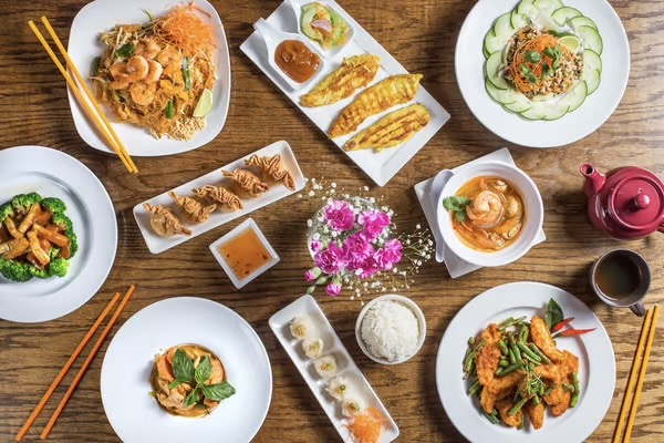 A set of delicious plates on a wooden table from Thai Tamarind.