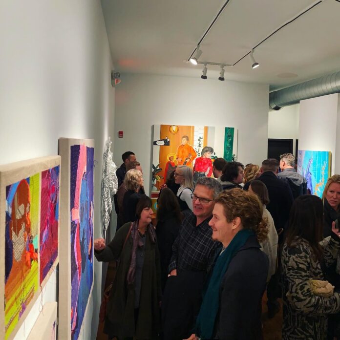 A crowd of people in Jeffrey Jarzynka's gallery looking to start buying art.