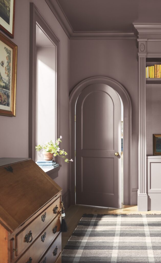 A mauve purple colors paints the walls of a doorway and door in the 2025 color of the year.