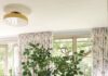 Sewickley Designer Betsy Wentz Makes a Historic Home Family-Friendly A white dining table with colorful chairs has a potted green plant sitting on top of it.