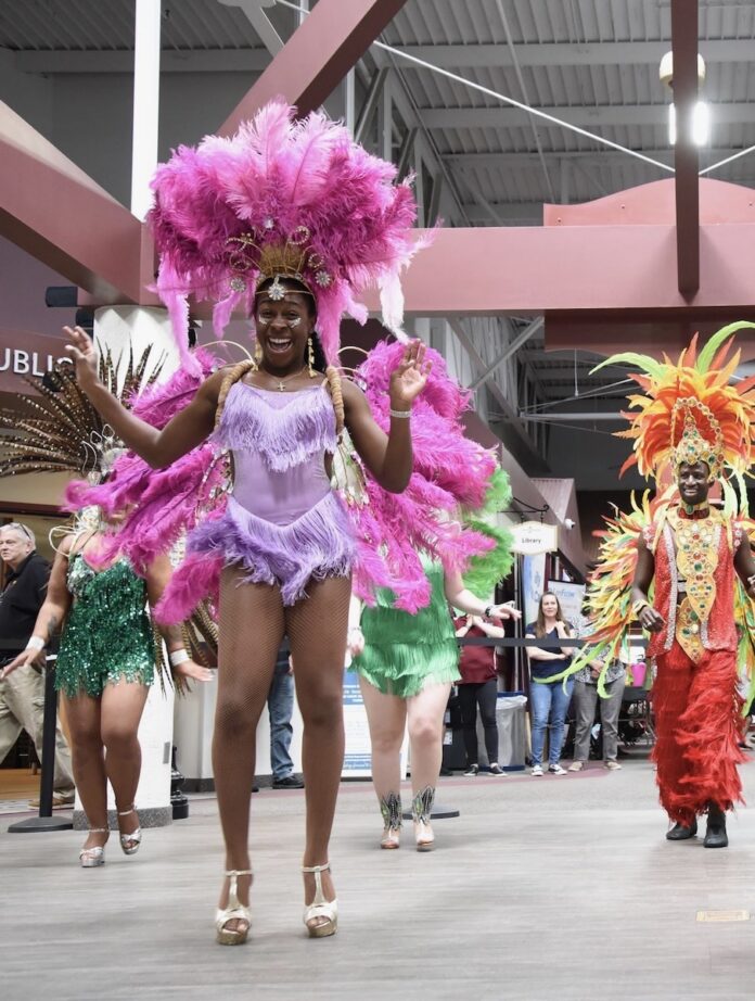 A group of people in colorful costumes dance at a festival in Pittsburgh.