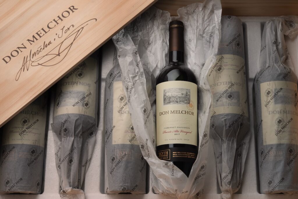 Various wine bottles for a wine dinner in Pittsburgh sit in a wood crate, wrapped in paper.