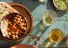Savory Chana Masala A large brown plate holds a variety of holi food including Chana Masala in two separate bowls.