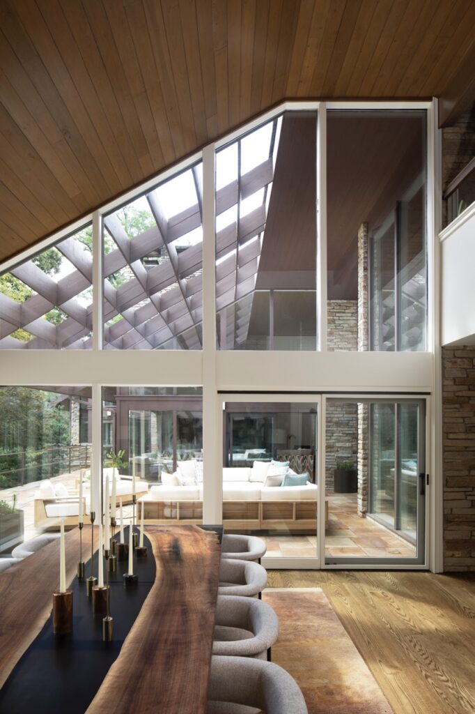 Large window panes showcase a bedroom in a wood panel room.