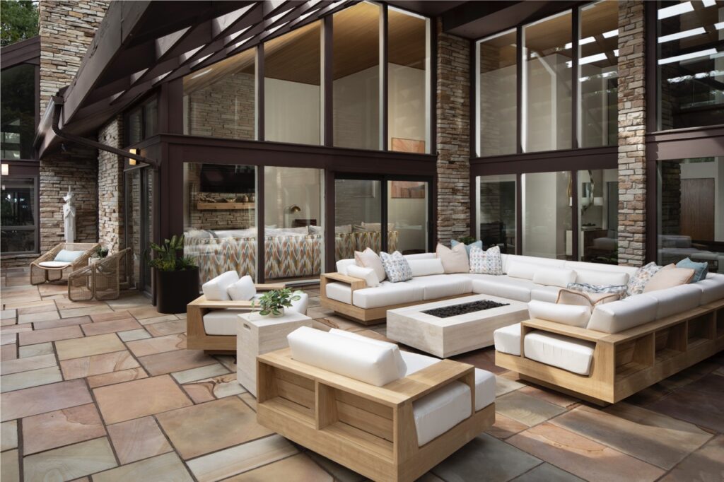 A white sectional outdoor couch sits on a tile patio designed by Seashal Belldina.
