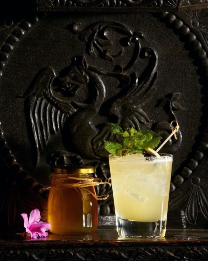 A bee's knees cocktail on a black background.
