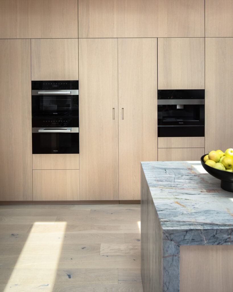 Pale wood cupboards line the walls as a dark marble sits in the middle of Tolga Sevdik from Richard DeShantz Restaurant Group's Kitchen.