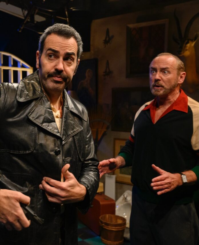 Your Must-See 2025 Pittsburgh Theater Performances Two men stand on a Pittsburgh stage, playing out a theater performance with one in a black leather jacket and grey hair and the other in a bowling type shirt and bald head.