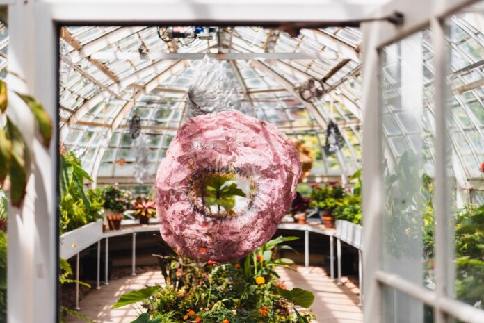 A mesh sculpture by Atticus Adams hangs in the Frick greenhouse
