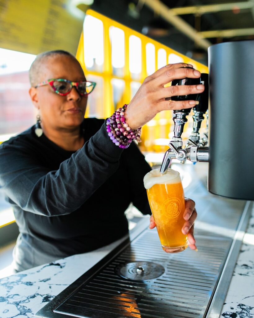 Jackie Page pours herself a beer at a Pittsburgh brewery.
