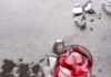 Don’t Knock Sipping Chilled Red Wine Two glasses of chilled red wine with ice cubes in them sit on a grey table with ice cubes scattered about.