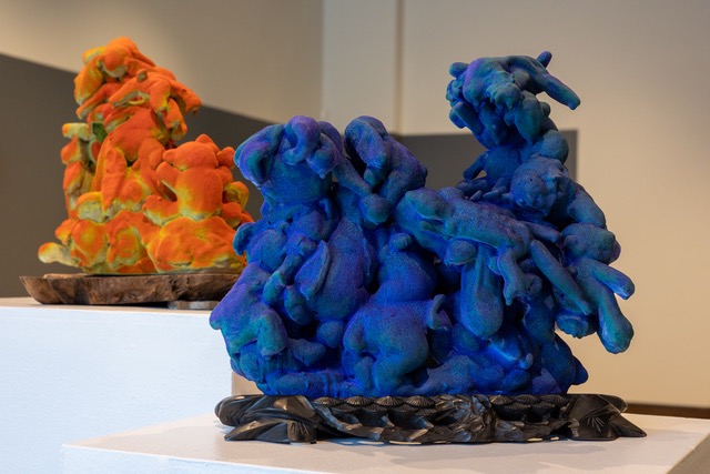 Two artist sculptures, one in blue blob shapes and the other in orange blob shapes.