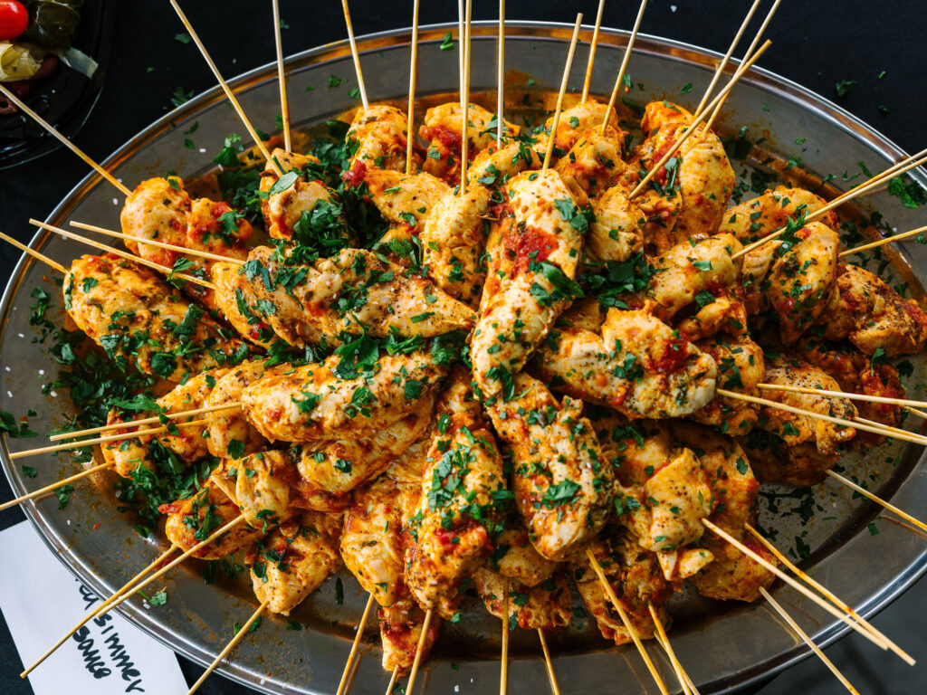 A plate full of chicken skewers.