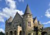 Historic Hotels for a Long Weekend in Western Pennsylvania A castle historic hotel with a green lawn and flower bushes.