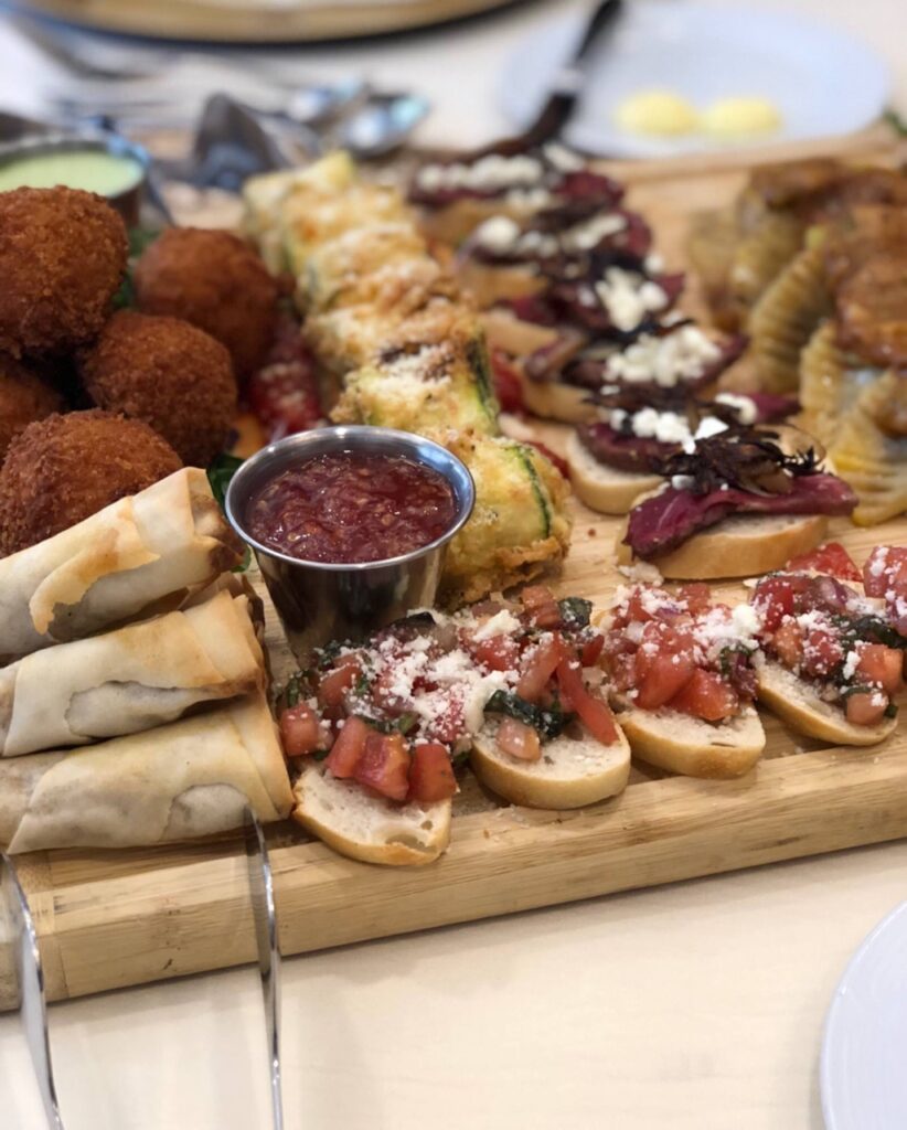 A tray of assorted Italian foods to try at a Tuscany event in Pittsburgh featuring crudités and fried bundles.