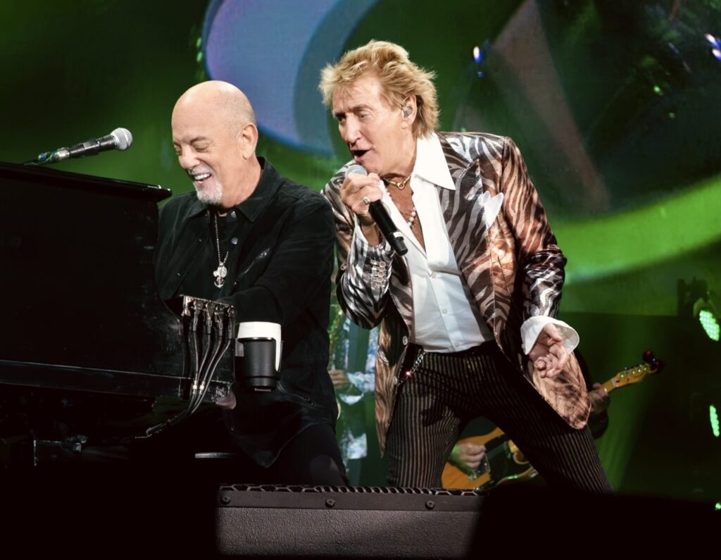 Billy Joel and Rod Stewart sing together in concert on stage in Pittsburgh.