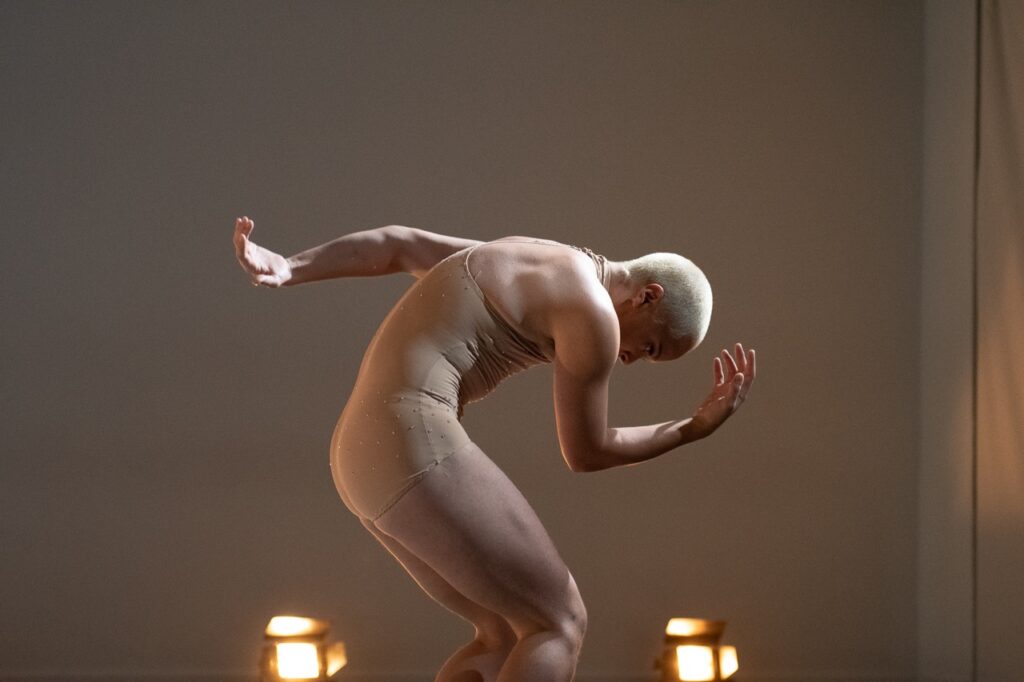 A man dancing in Pittsburgh leans over into a thinking man pose.