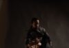 The Top Pittsburgh Dance Performances of 2025 A man and woman in black dance together on a dark black background.