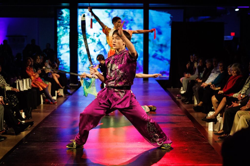 Two kung fu performers on a red fashion runway.