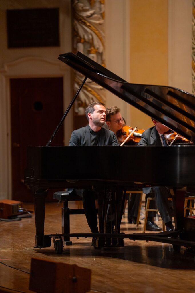 A man sits at a piano on stage at a symphony show in Pittsburgh.
