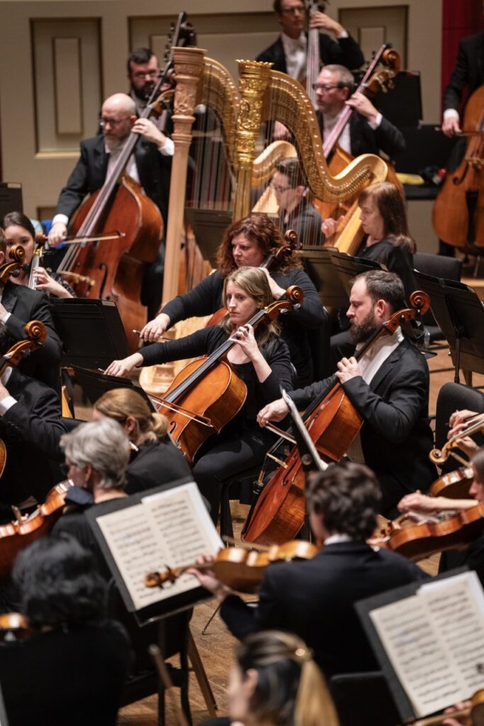String members of Pittsburgh Symphony Orchestra sit and play on stage.