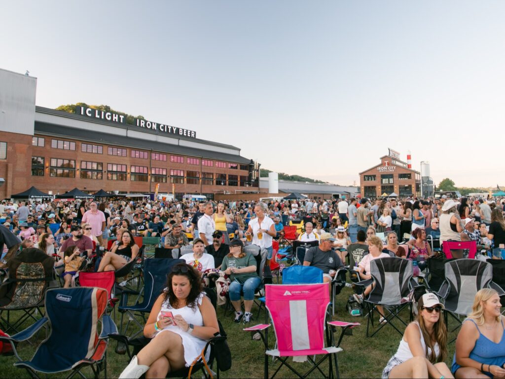 People sit out on a lawn in Pittsburgh for a rockin regatta.