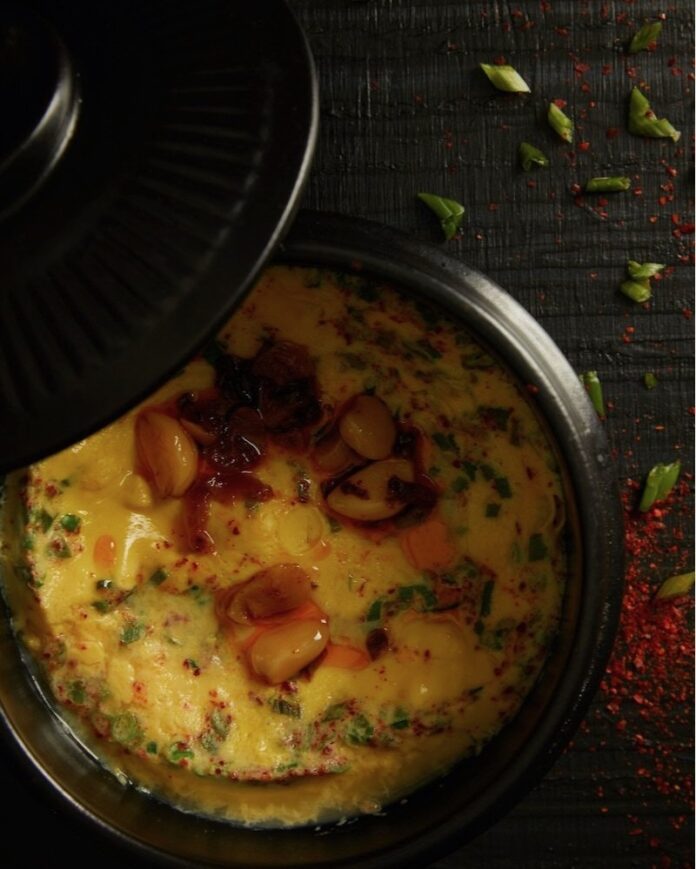 A plate of Korean stamed eggs on a black surface.