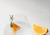 11 Easy, Classic, and Craft Gin Cocktails An Italian gin and tonic with an orange slice on a white background