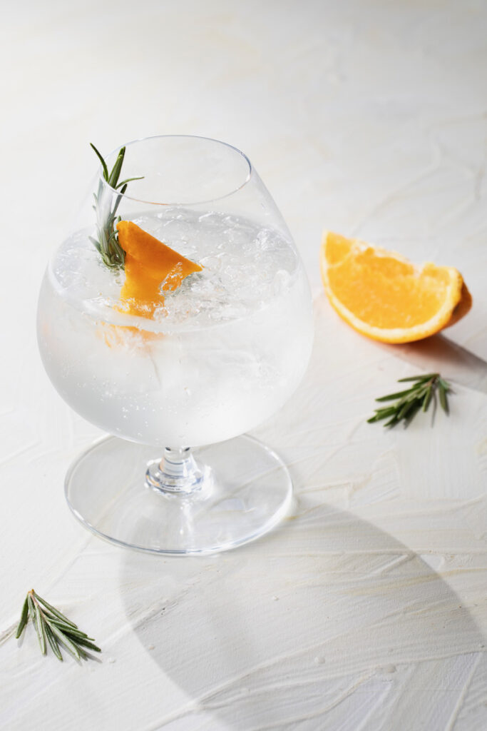 An Italian gin and tonic with an orange slice on a white background